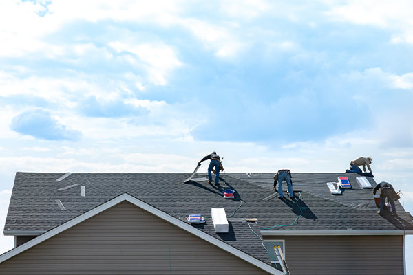 a group of men on the roof of a house during roof installation in woodbury